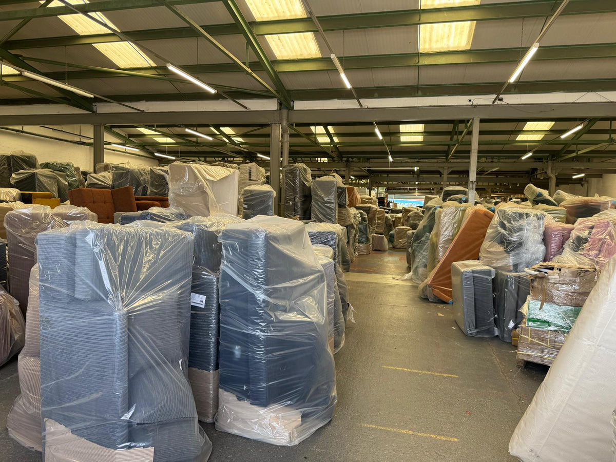 Sofas wrapped and stacked in the warehouse, built to order and ready for delivery