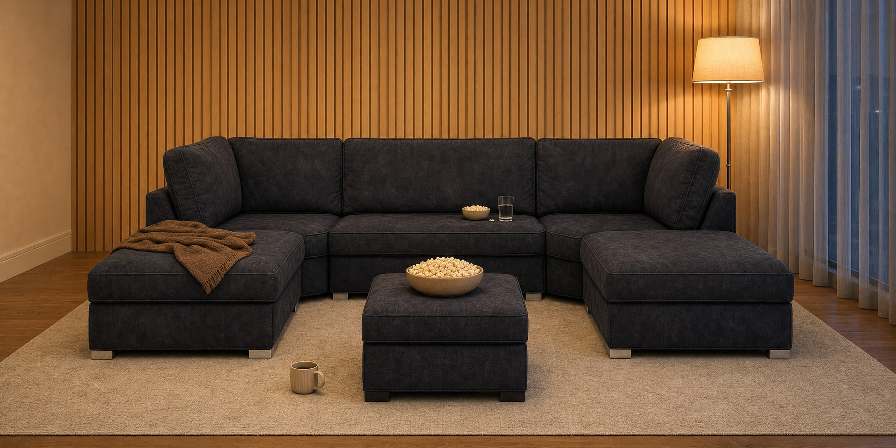 Bishop U-shape sofa in black faux leather with matching footstool in a living room